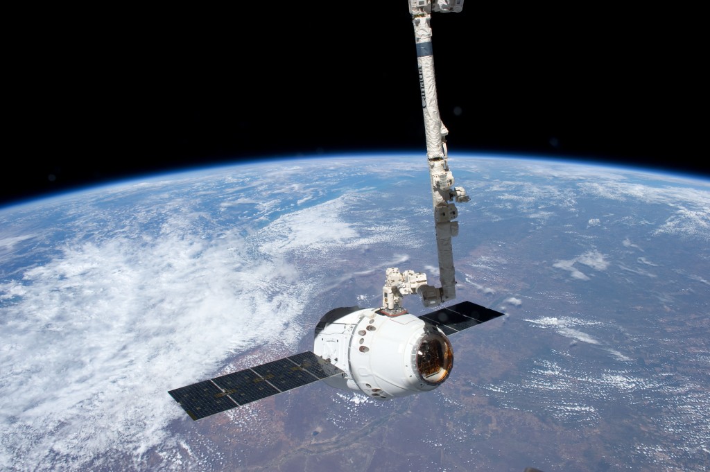 La navette Dragon accroché par le bras de l ISS.